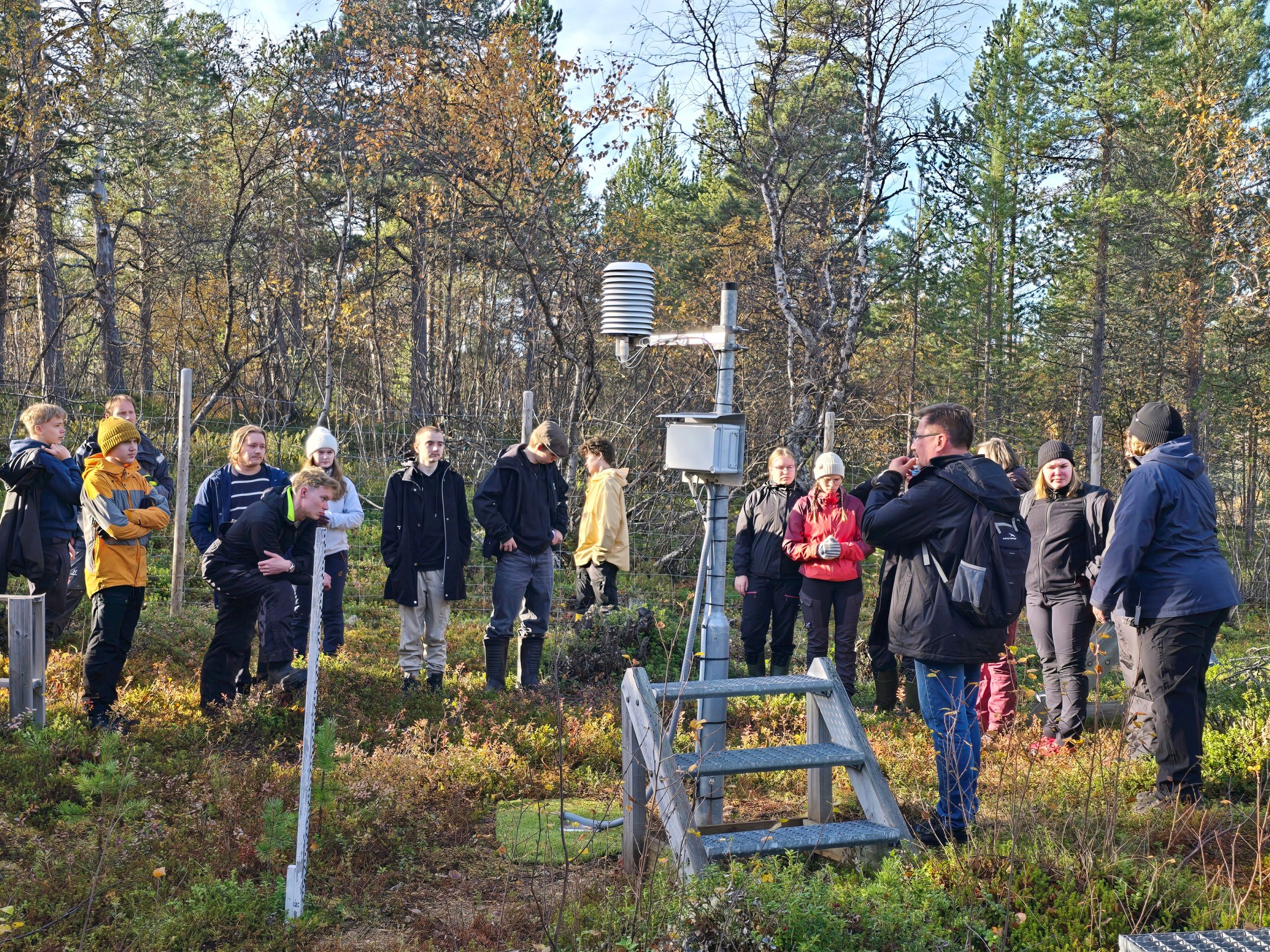 nuoria ihmisiä lappilaisessa metsässä tutustumassa tutkimusasemaan