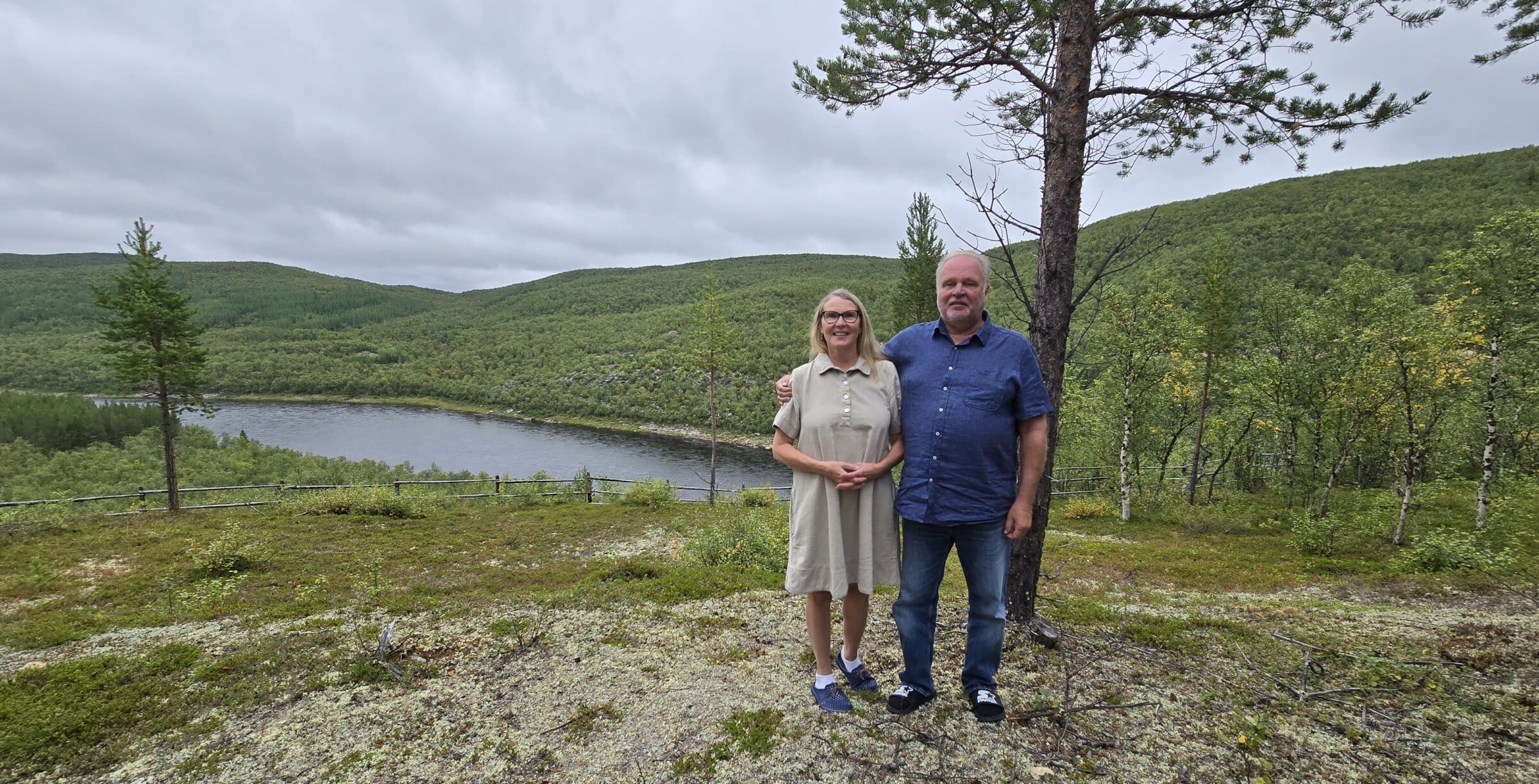 Pariskunta seisoo joen törmällä