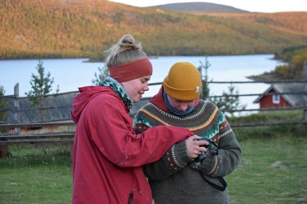 kaksi nuorta naista tutkii kameraa