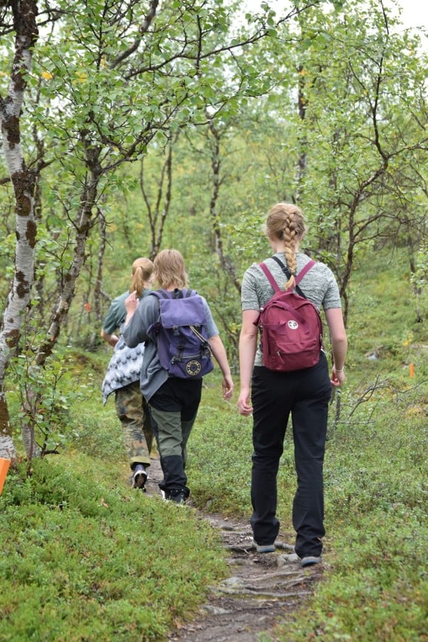 Nuoria reppuineen metsäpolulla